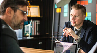 Two men in meeting discussing business strategy.